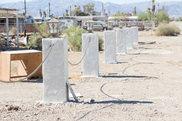 CalSpaces 218 Six concrete pillars with chains connecting them in a desert landscape.