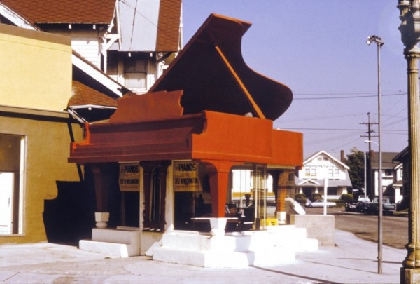 A building with an entrance shaped like a piano. the piano is red!