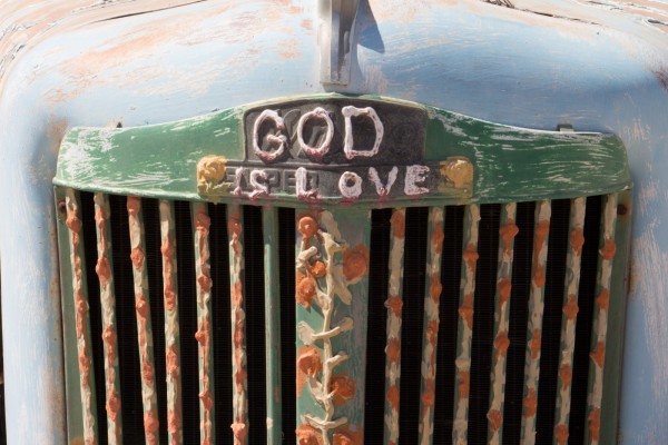 The grill of an embellished truck with flowers and GOD IS LOVE