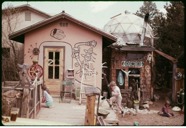 Two children play in front of a decorated house.
